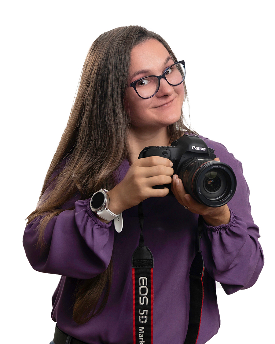 woman wearing glasses and purple shirt holding professional camera